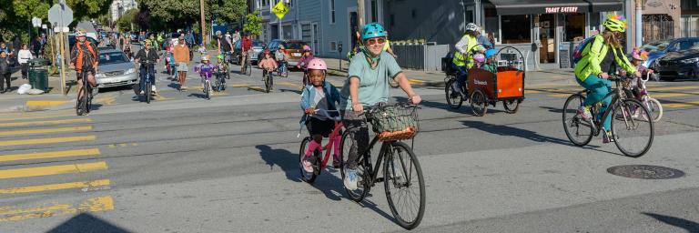 교차로를 통해 함께 자전거를 타는 성인과 어린이