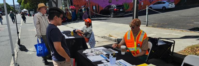 SFMTA staff discussing the Valencia Streek Bikelane at a recent Sunday Streets event on Valencia