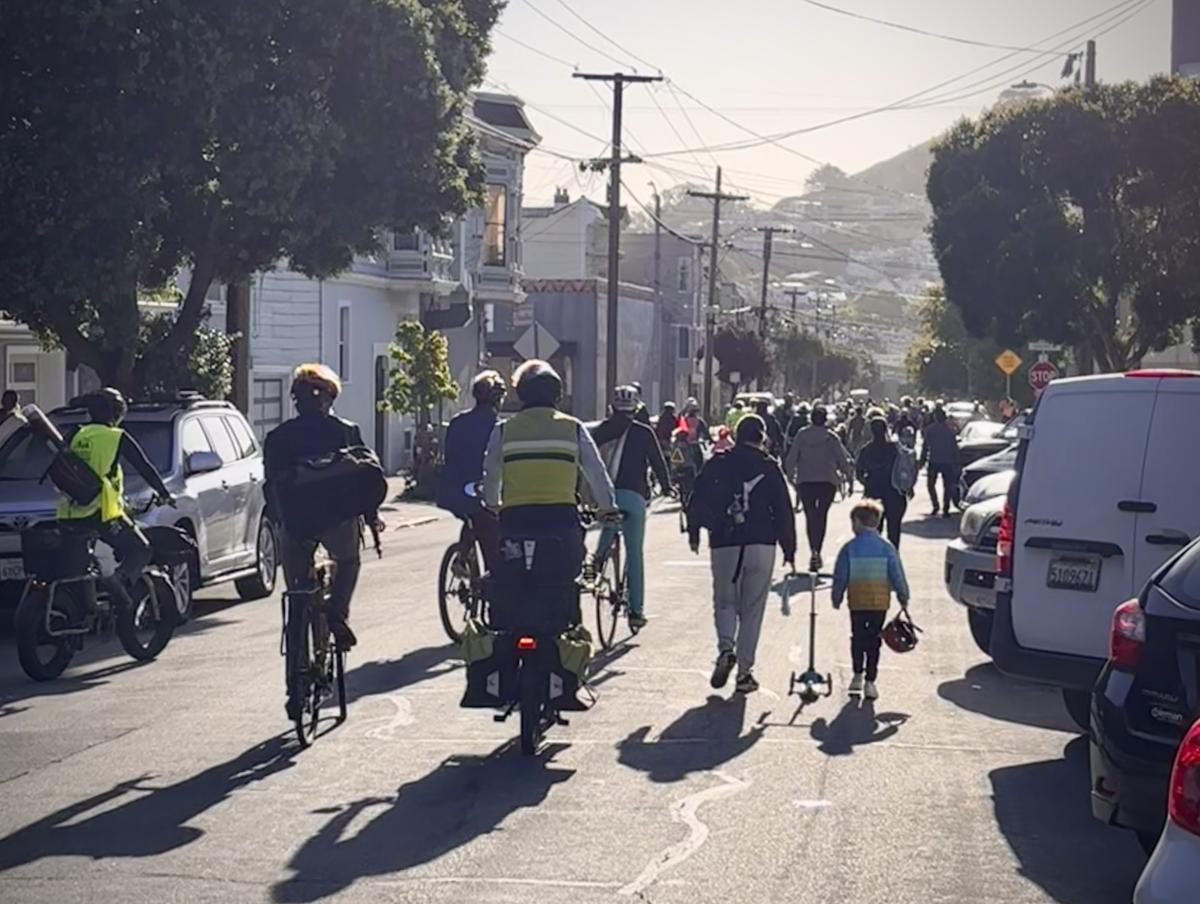 People on bicycles and walking down a street