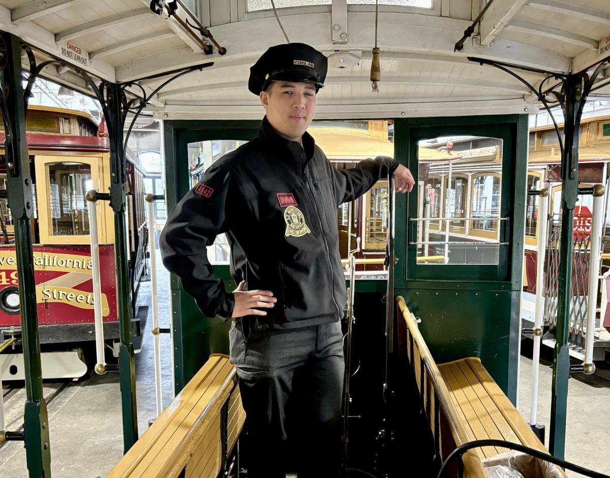 A cable car operator stands in a cable car.