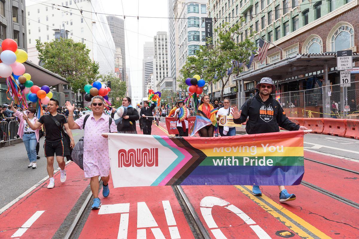 SFMTA staff holding banner and marching on Market Street during the SF Pride Parade