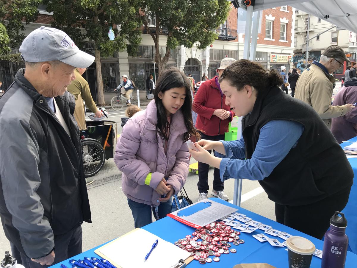 SFMTA staff showing event attendees a paper train 