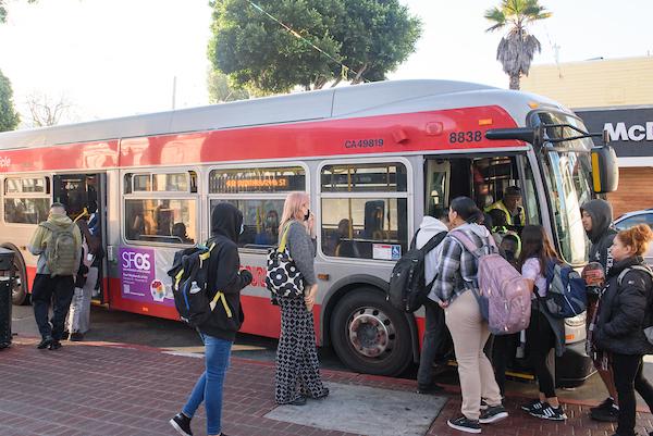 People stand in line to board the 48 Quintara at 24th and Mission streets.