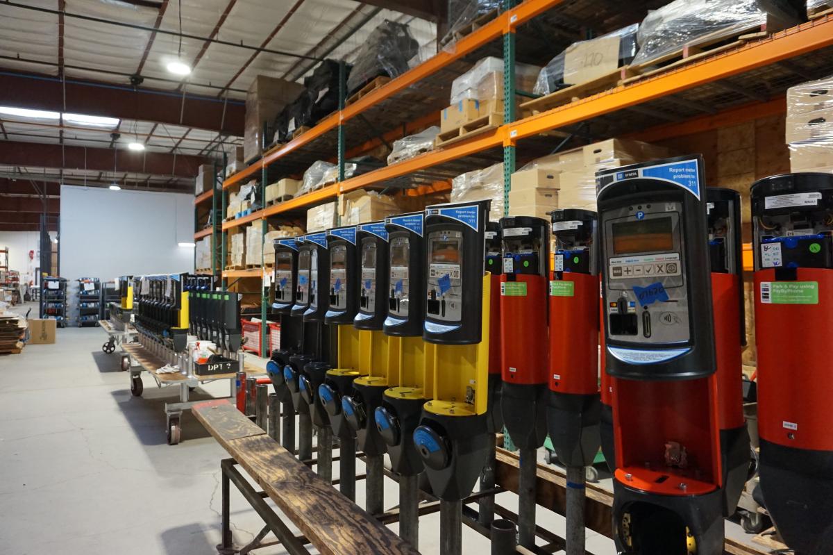 A row of upgraded parking meters that are red, yellow and blue in one of our shops.