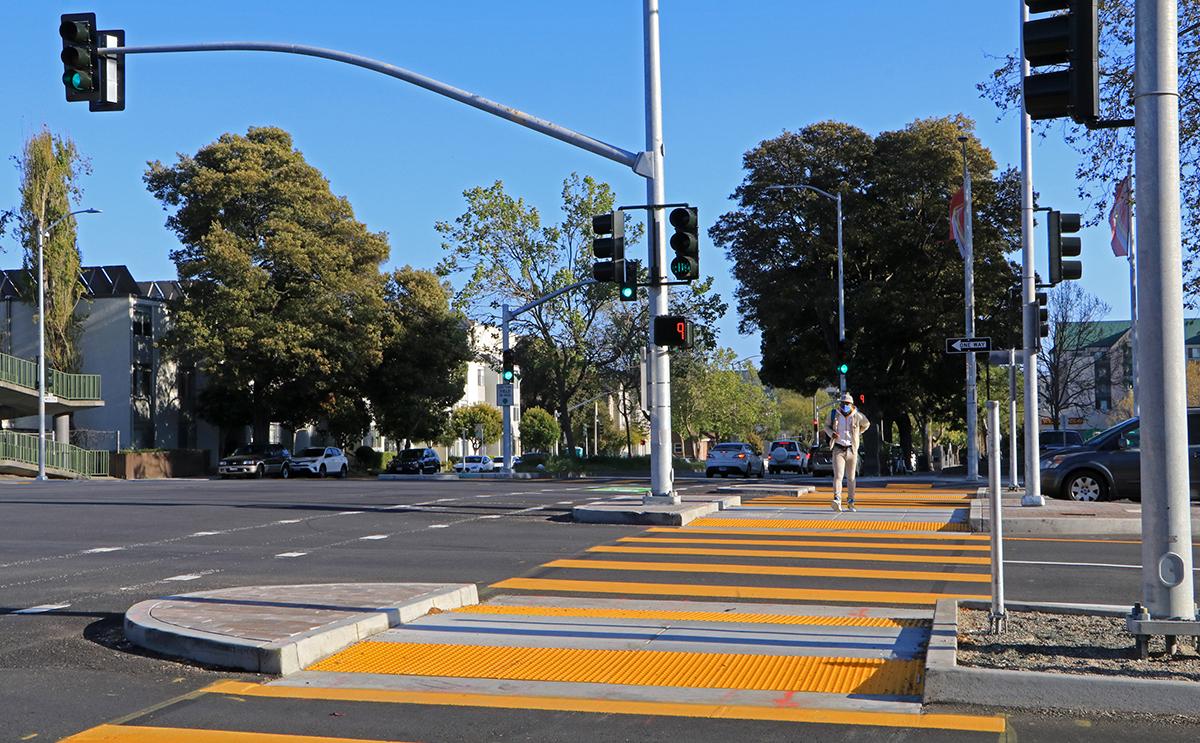 Photo of person crossing at improved crosswalk at Geary and Webster.