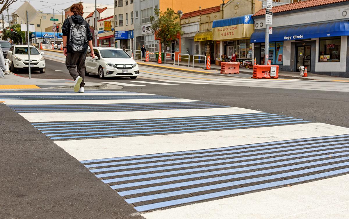 Close-up of a high-visibility crosswalk on Taraval. Features blue and white colors to create a strong visual contrast for people driving in the area.