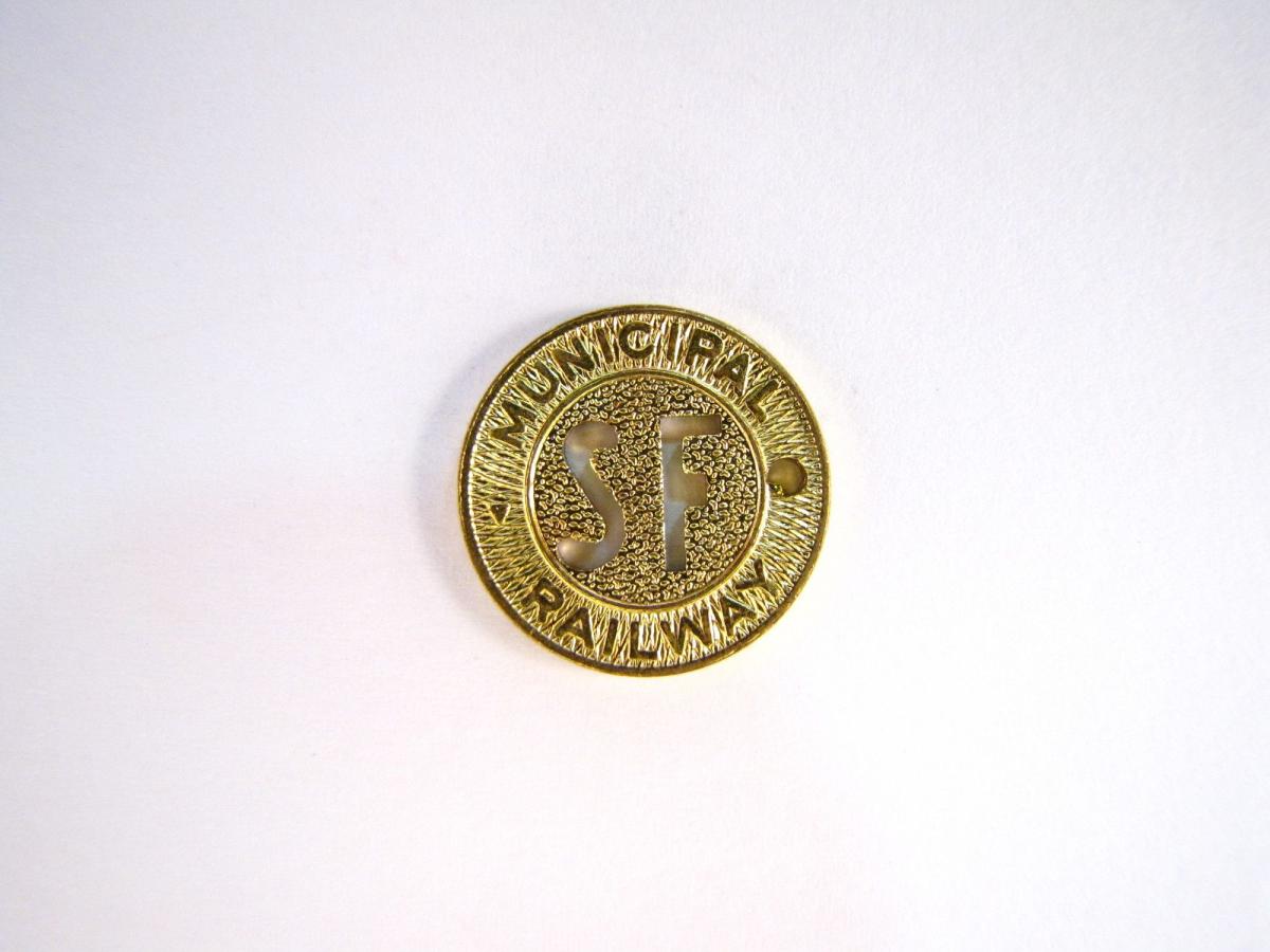 Image of a gold Muni token with "SF" in the center and "Municipal Railway" on the edges.