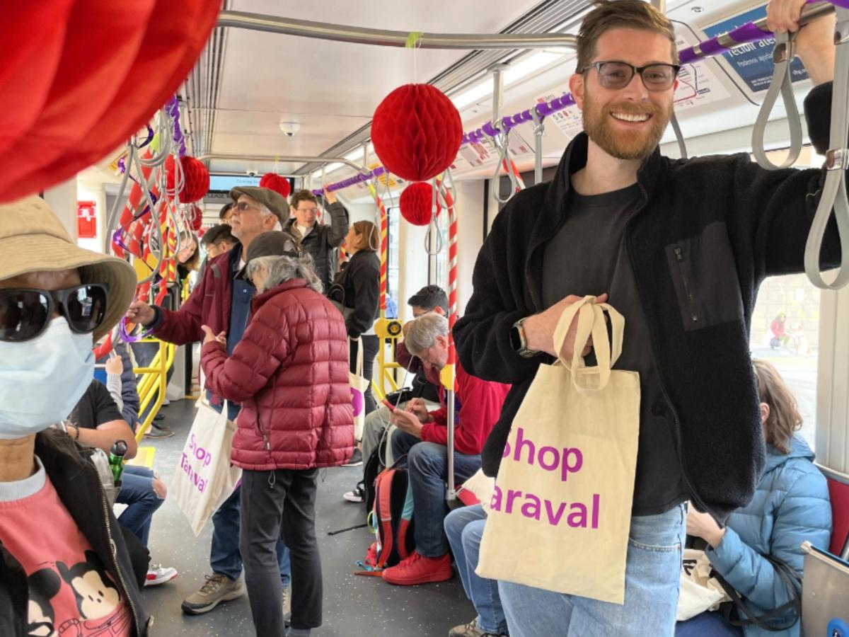 People smile and stand inside an L Taraval train that's decorated to mark the completion of the L Taraval Improvement Project.