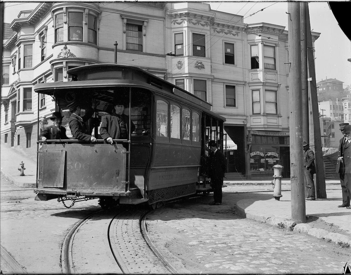 An archival photo, in black and white, of a cable car turning at the intersection of Jackson and Mason streets in San Francisco in 1910.