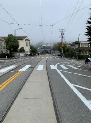 On Ulloa Street, the traffic lane is painted to be more narrow in advance of the crosswalk at Wawona Street