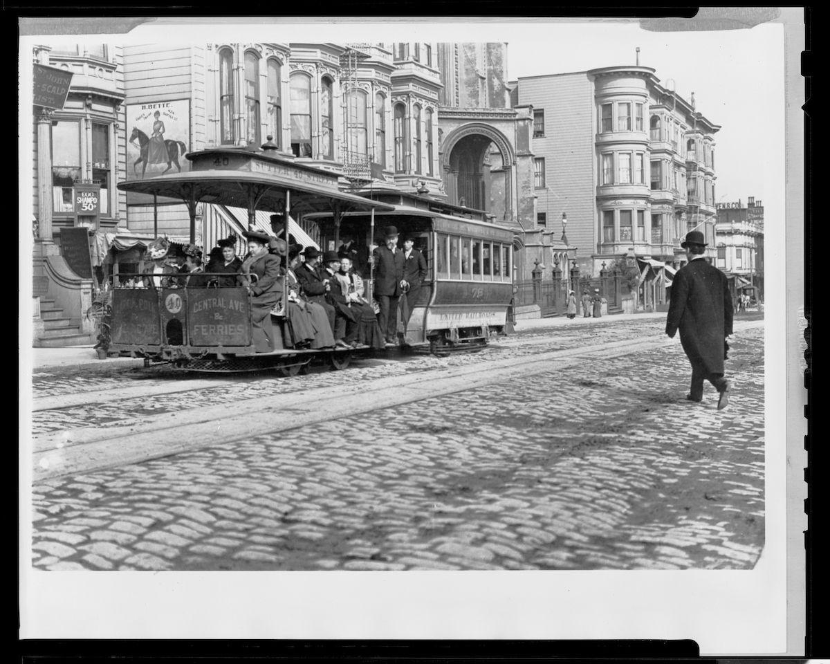 An archival photo, in black and white, featuring a cable car with passengers. It was taken around 1905.