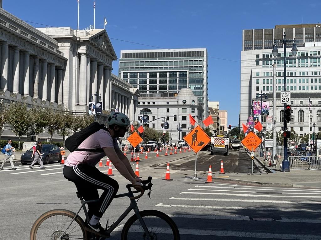 Image of cyclist riding past construction on Dr. Carlton B. Goodlett Place