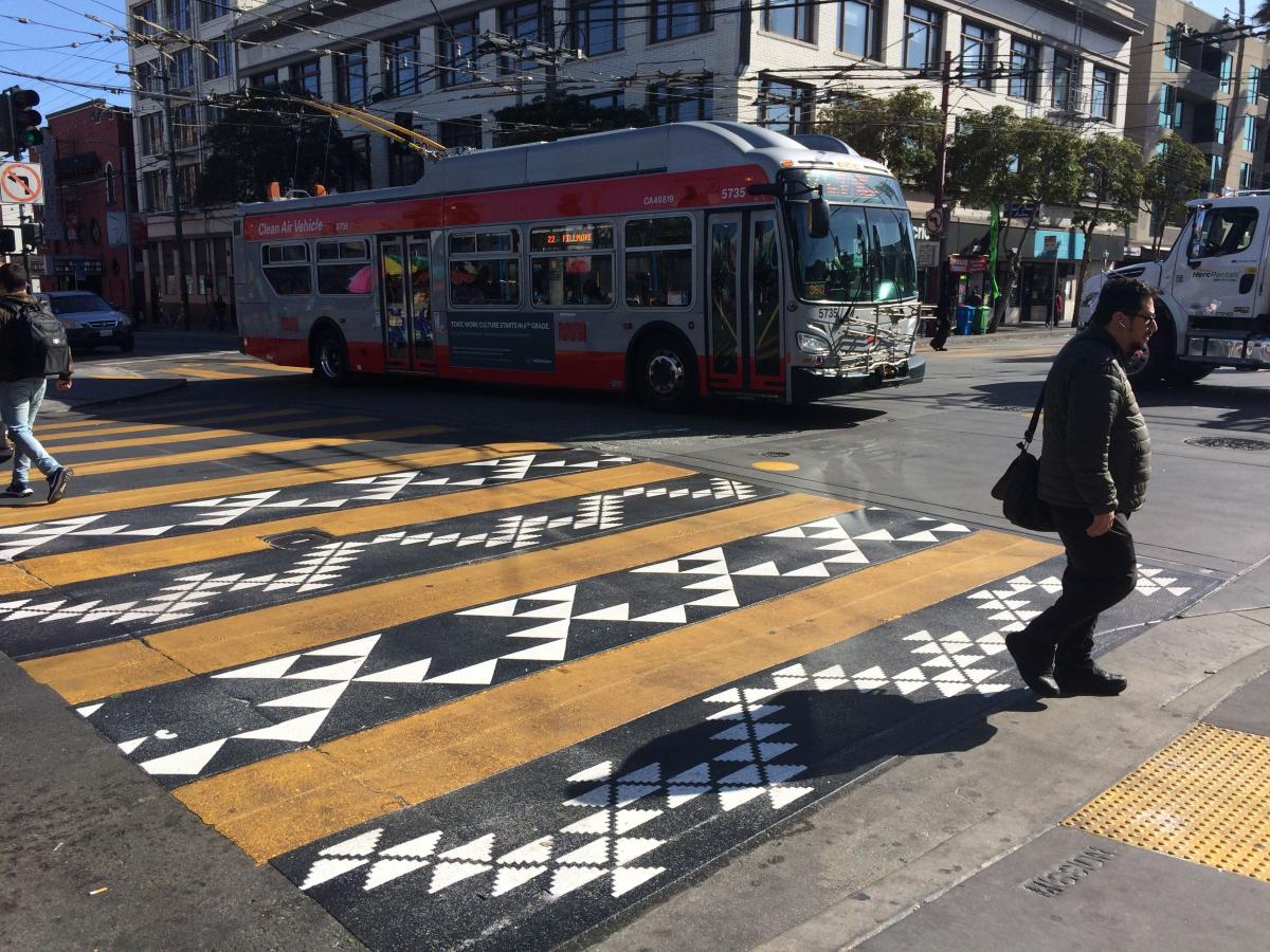 Pedestrian walks across the first portion of the decorative crosswalk.