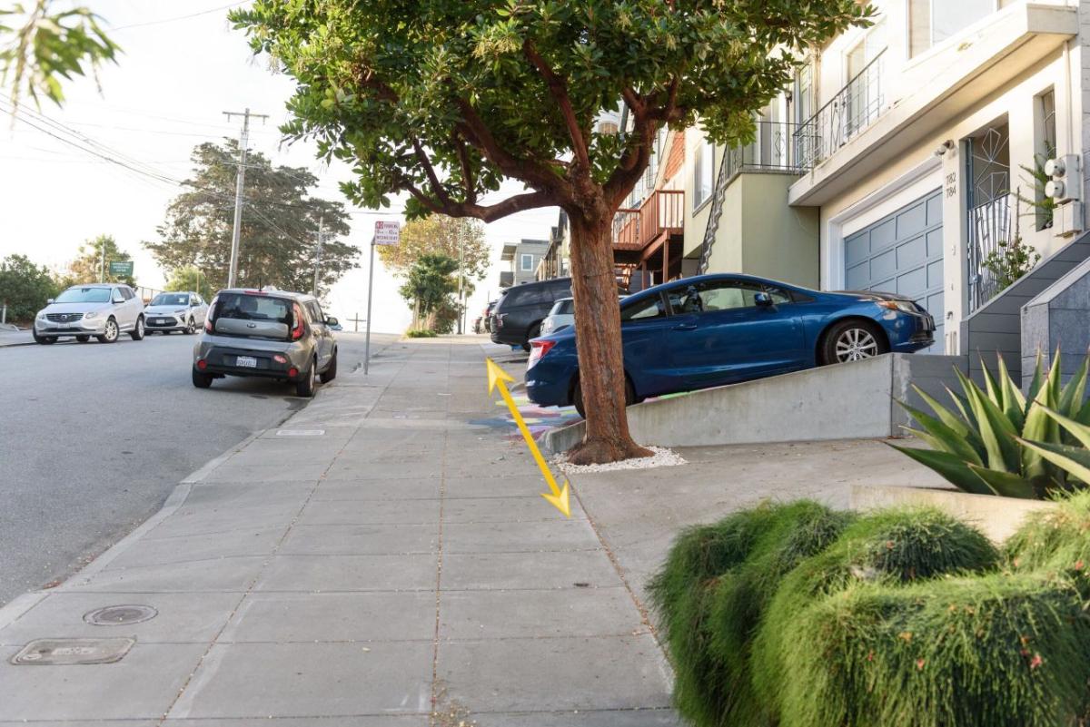 Image shows a blue car parked correctly in a driveway because it does not block any part of the sidewalk. A yellow arrow behind the car illustrates this.