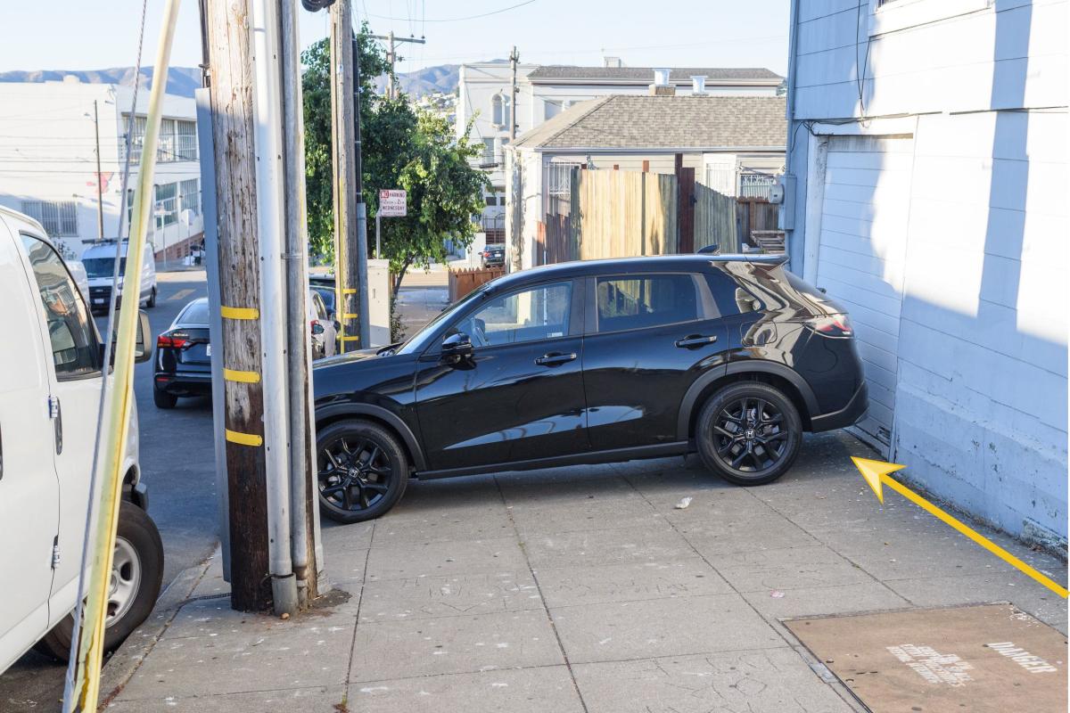 Image shows a vehicle completely blocking the sidewalk, which is made clear by a yellow arrow near the car.