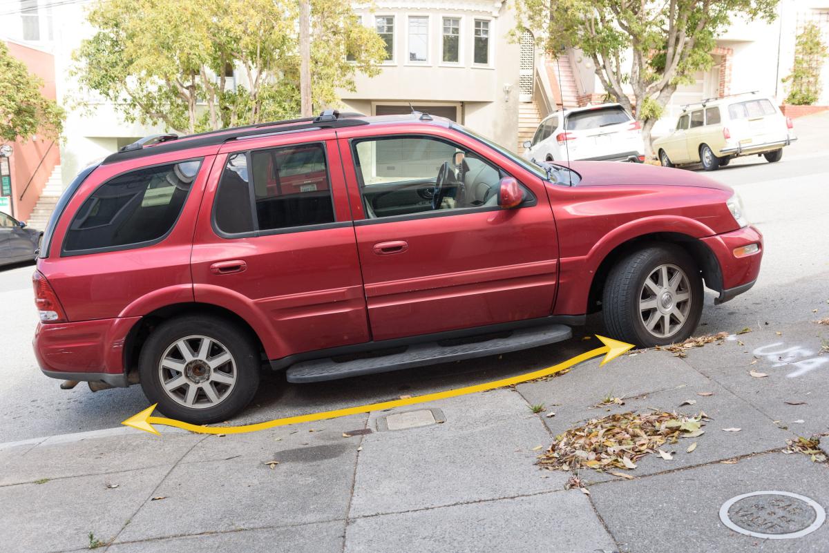 Image shows a vehicle parked legally alongside a "curb cut" because it does not block the sidewalk, shown by a yellow arrow along the curb cut.