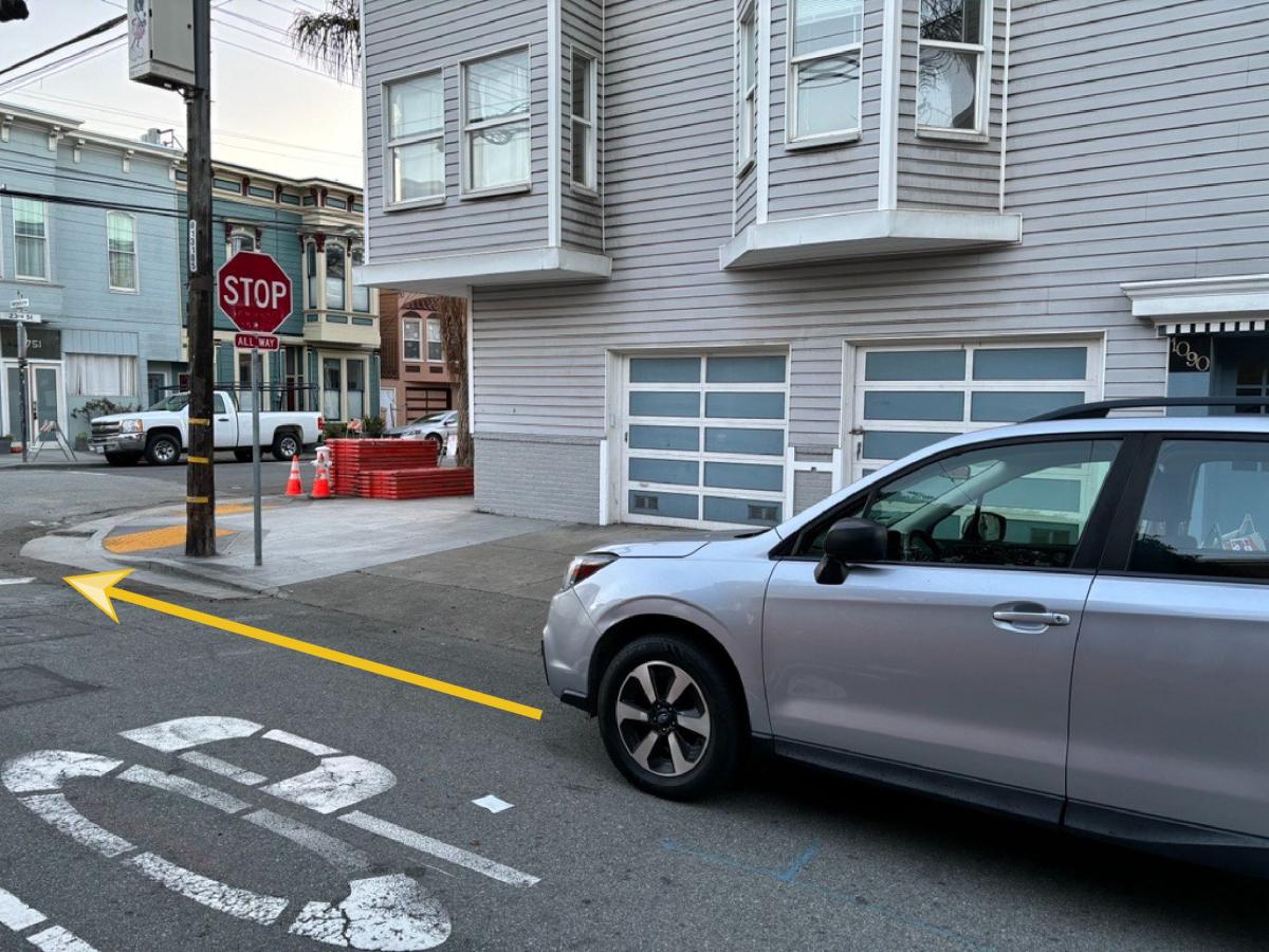 Image shows a vehicle parked legally near a corner home, illustrated by a yellow arrow showing how the placement aligns with California's daylighting law.