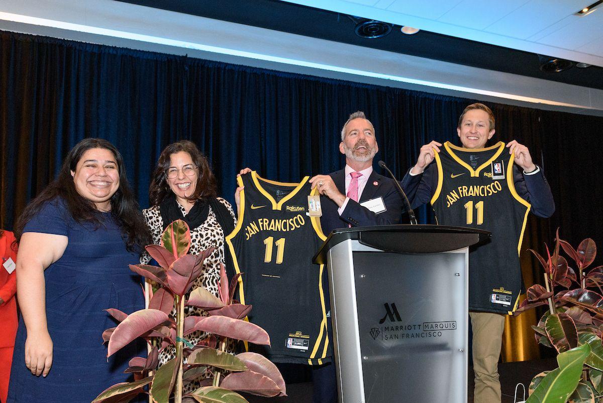 Attendees of the 2024 Save Driver Awards event hold special jerseys donated by the Warriors.