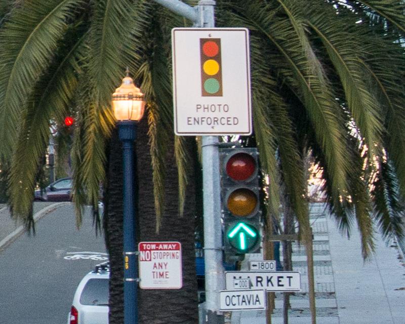 交通號誌和紅燈攝影機上寫有「照片強制執行」標誌的特寫