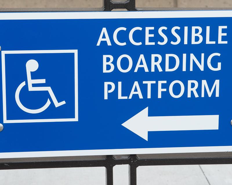 closeup of blue sign reading "accessible boarding platform" with arrow pointing to the left