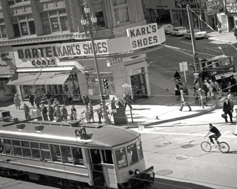 Historic image of trolley card, people walking along city street