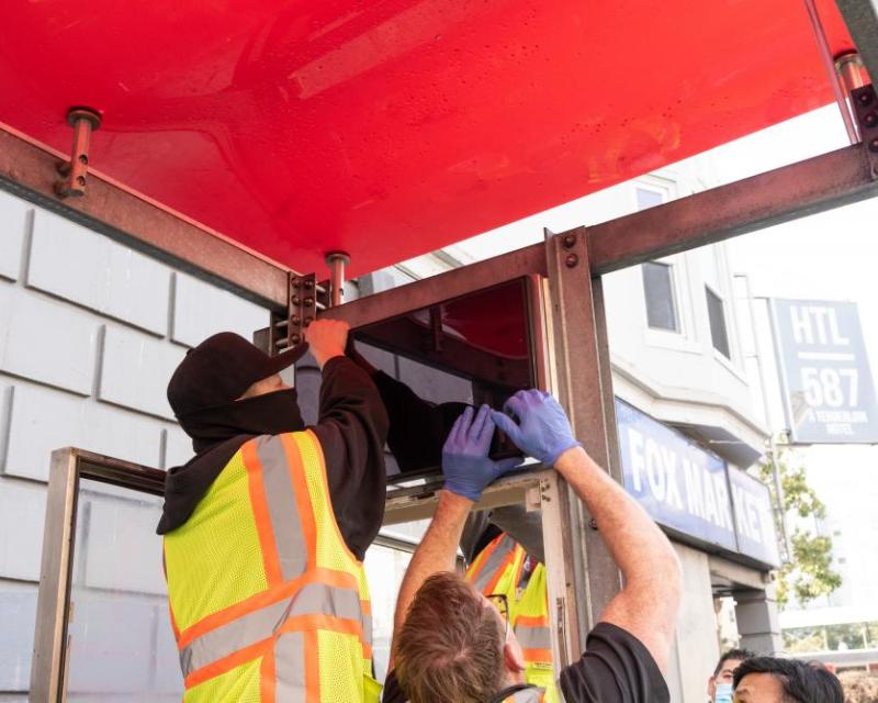 Crews installing the new customer information sign 