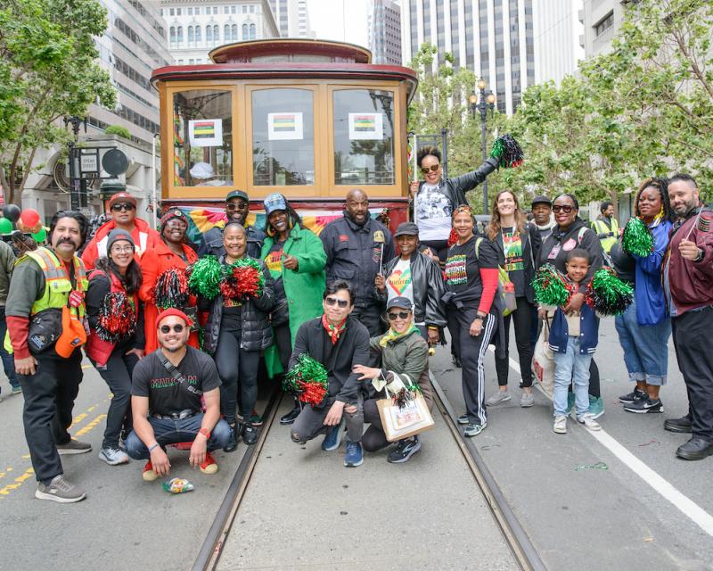 People standing in the street in front of a motorized cable car.