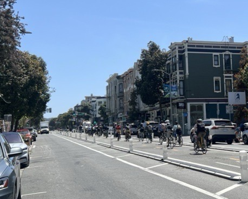 People bike on the center-running bikeway on Valencia Street.