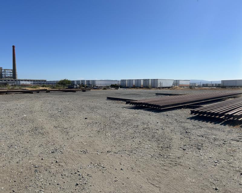 The four acre gravel storage lot adjacent to the Muni Metro East facility with the rail spikes that are currently being stored there.