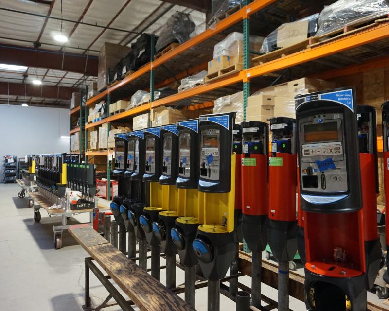 A row of upgraded parking meters that are red, yellow and blue in one of our shops.