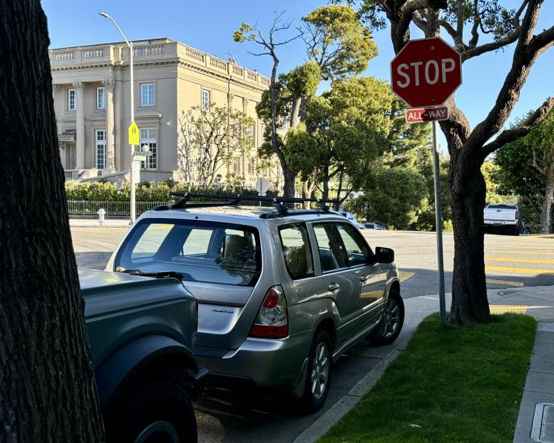 A car parked next to a stop sign.