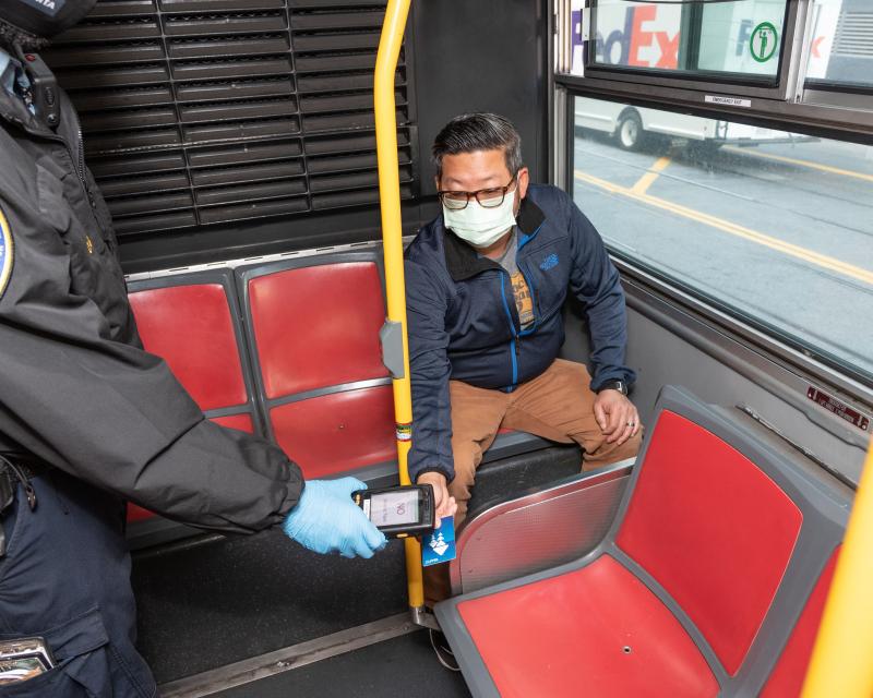 Inspector checks fare on a rider's Clipper Card. 