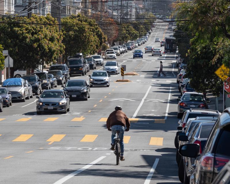 A person riding their bike on new bike lanes installed as part of the Anza Street Bike Lanes Project