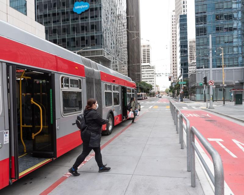 Rider steps off a Muni bus on Market Street.