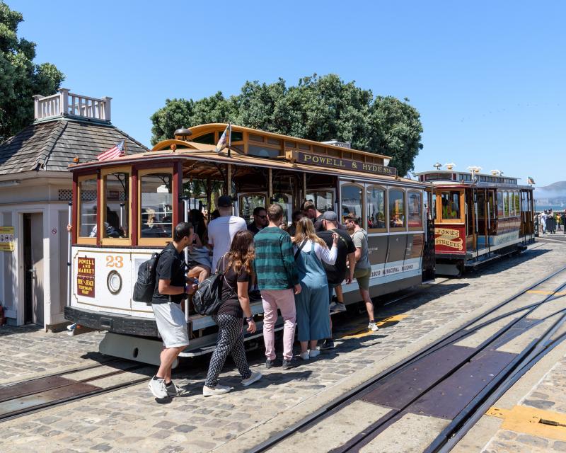 Several people board a cable car near Fisherman's Wharf.