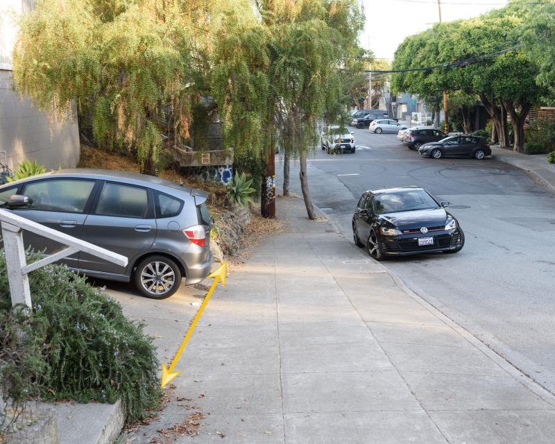 Image shows a vehicle parked legally in a driveway, with a yellow arrow illustrating that the car does not block the sidewalk.