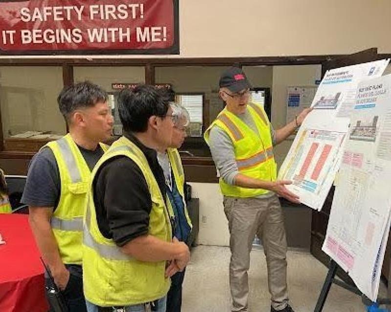 MUNI bus yard workers watching a presentation with SFMTA Staff discussing Project details