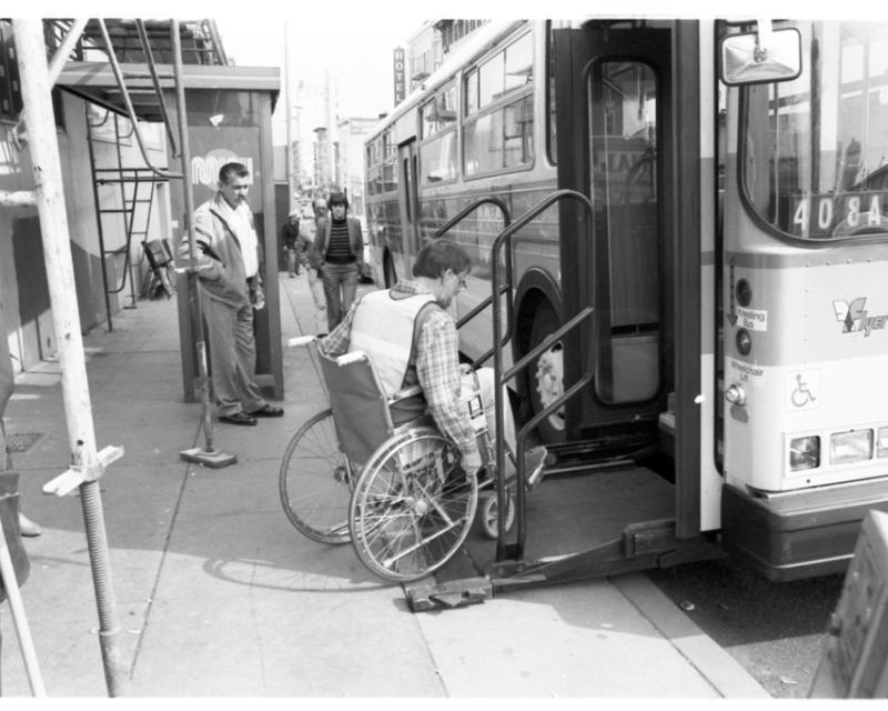 person sitting in wheelchair boarding bus