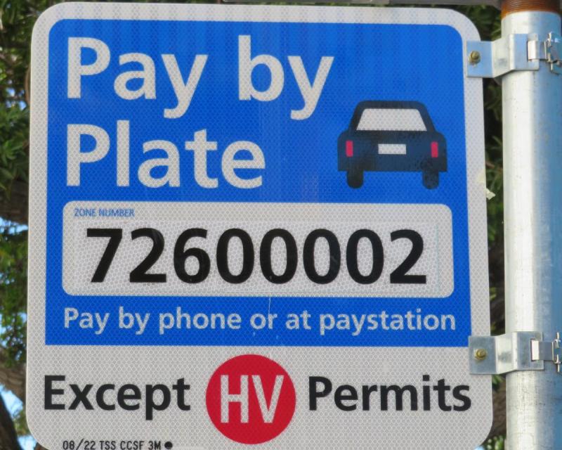 sign that says Pay by Plate (pay by phone or at paystation) Except HV Permits