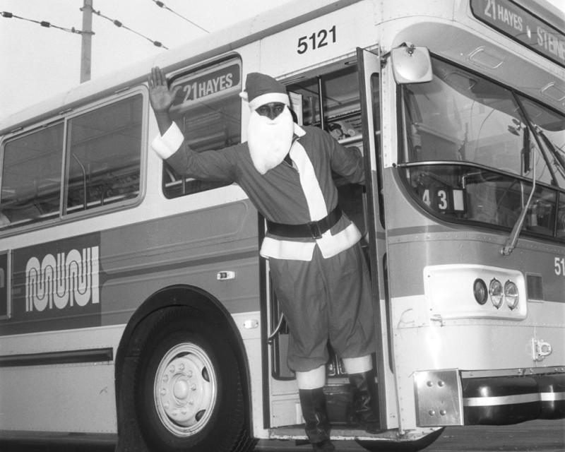 person dressed as santa waving to camera from bus