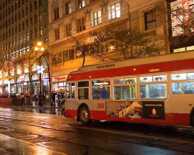 Coach traveling down a rainy street.