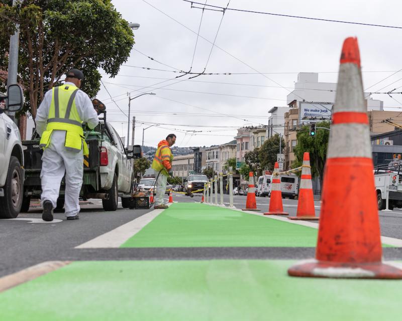 crews installing green bike paths