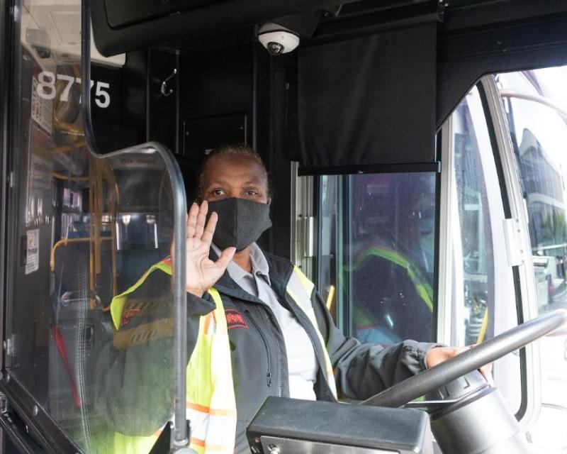 Photo of Muni operator behind the wheel, wearing a mask