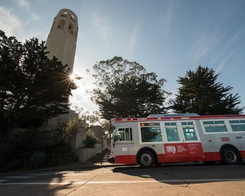 Photo depicting a Muni bus next to Coit Tower.