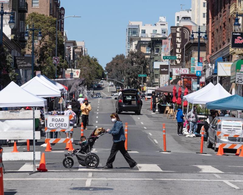 Photo of a street closed in the Tenderloin during summer 2021 with vendors and pedestrians
