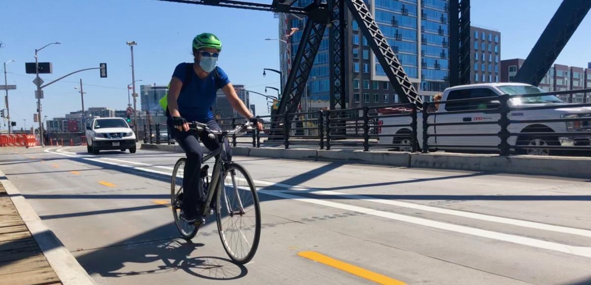 man biking over Third Street Bridge